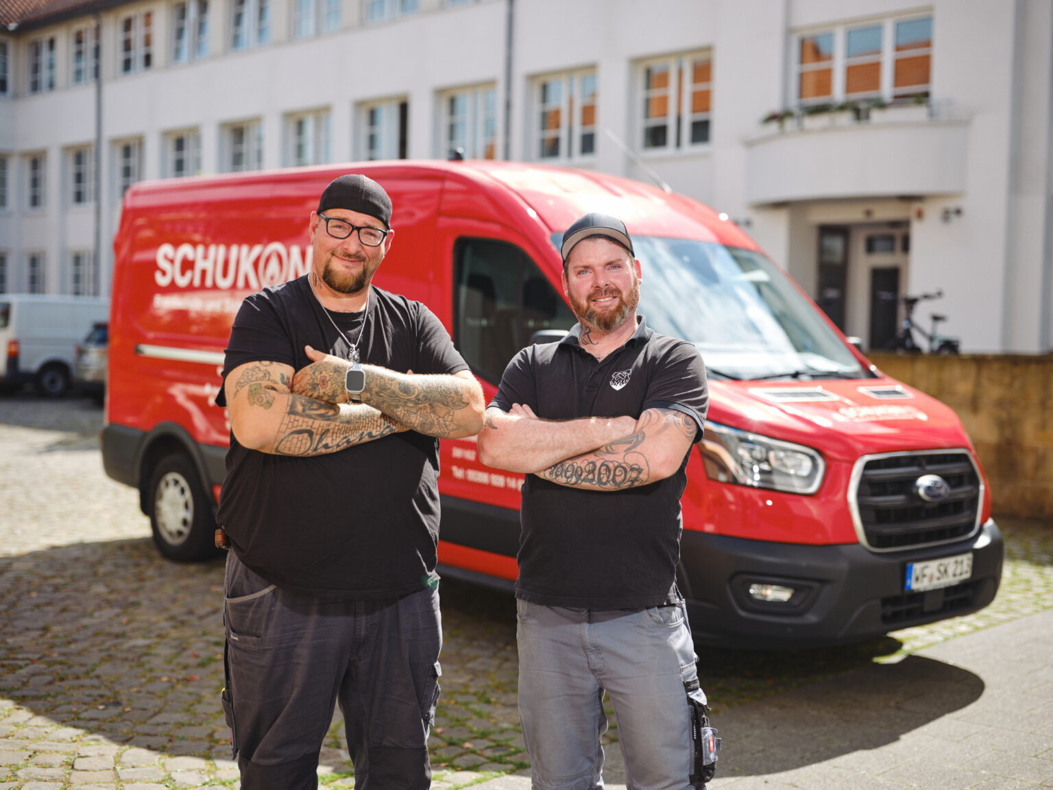 Zwei Monteure von SCHUKON vor dem Servicefahrzeug